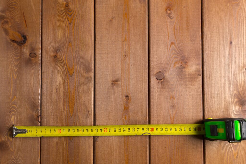 Tape measure on wooden background. top view.